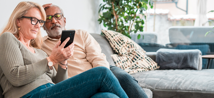 Actor portrayal of an elderly couple looking at a phone together