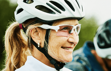 Actor portrayal of an elderly woman wearing a bike helmet